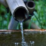 Utilisé comme des tuyaux, des bambous apportent l'eau bienfaitrice dans un récipient. Un exemple de la simplicité taoïste en action.