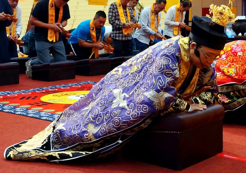 Maître Huang se prosternant devant le divin